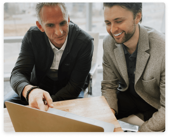 two guys at laptop working and smiling